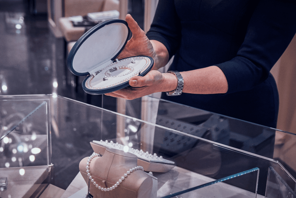 a lady holding a jewellery box with jewellery inside, inside a jewellery shop